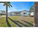Well-kept home showcasing a manicured lawn, palm trees, and a blue front door at 105 12Th Sw St, Ruskin, FL 33570