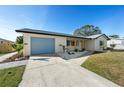 Charming home exterior featuring a light blue garage door, fresh landscaping, and a well-maintained lawn at 105 12Th Sw St, Ruskin, FL 33570