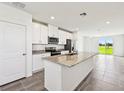 Bright kitchen featuring stainless steel appliances, granite counters, and an open layout with access to the outdoors at 14005 Crutchfield Ct, Parrish, FL 34219