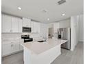 Modern kitchen featuring white cabinets, stainless steel appliances, and a spacious center island at 14076 Crutchfield Ct, Parrish, FL 34219