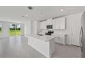 Bright open kitchen with a center island, stainless appliances and sliding glass doors leading to the backyard at 14076 Crutchfield Ct, Parrish, FL 34219