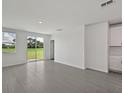 Bright living room with tile flooring, sliding glass doors, and backyard views at 14076 Crutchfield Ct, Parrish, FL 34219