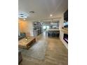 Open-concept living and kitchen area, featuring modern finishes, an electric fireplace, and wood-look tile floors at 9153 86Th Ave, Seminole, FL 33777