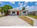 Inviting single-story home with a red door, neutral siding, and well-maintained front yard at 4111 13Th S Ave, St Petersburg, FL 33711
