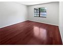 A bright bedroom features a hardwood floor and a window at 6623 Baybrooks Cir, Temple Terrace, FL 33617