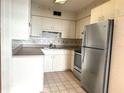 Traditional-style kitchen featuring stainless steel appliances and white cabinets at 129 104Th Ave # 205, Treasure Island, FL 33706