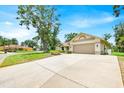 Spacious driveway leads to a charming single-story home with well-kept landscaping at 2900 Hammock Dr, Plant City, FL 33566
