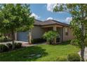 Charming home featuring a two-car garage and well-manicured lawn with mature trees and tasteful landscaping at 8410 Red Spruce Ave, Riverview, FL 33578