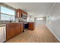 Well-lit kitchen featuring stainless steel appliances, tile backsplash, and wood-look flooring at 5141 Oakland Hills Ave, Sarasota, FL 34234