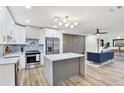 Bright open-concept kitchen with marble island and stainless appliances, flowing into the stylish living area at 203 Driftwood W Dr, Palm Harbor, FL 34683