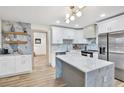 Modern kitchen with white cabinets, stainless steel appliances, marble countertops, and stylish lighting fixtures at 203 Driftwood W Dr, Palm Harbor, FL 34683