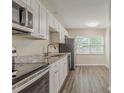Modern kitchen featuring stainless steel appliances, granite countertops, and sleek white cabinetry at 3944 11Th S Ave, St Petersburg, FL 33711