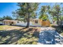 Single-story home with a well-maintained lawn, driveway, and secure wooden fence at 6940 82Nd N Ave, Pinellas Park, FL 33781