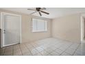 Bright living room with tiled floors, a ceiling fan, and a door for easy access at 6940 82Nd N Ave, Pinellas Park, FL 33781
