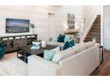 Cozy living room with a plush sofa, coffee table, TV, and staircase leading to the second floor at 1031 Signet, Apollo Beach, FL 33572