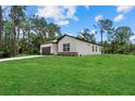 Side view of a single-Gathering home with a well-manicured lawn, a two-car garage, and a neutral color scheme at 2682 Edwin Ave, North Port, FL 34288