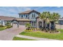 Beautiful two-story home featuring a stone facade, tile roof, three-car garage, and well-manicured landscaping at 29043 Picana Ln, Wesley Chapel, FL 33543