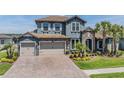 Beautiful two-story home featuring a stone facade, tile roof, three-car garage, and well-manicured landscaping at 29043 Picana Ln, Wesley Chapel, FL 33543