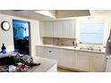Kitchen featuring white cabinetry, stainless steel sink, and a window for natural light at 4719 Alcazar S Way, St Petersburg, FL 33712