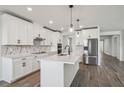 Well-lit kitchen featuring an island with white cabinets, stainless steel appliances, and modern pendant lighting at 1780 Draughton Dr, Zephyrhills, FL 33541