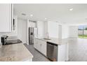 Bright open-plan kitchen with stainless steel appliances and a central island that overlooks the backyard at 1828 Brekey Way, Zephyrhills, FL 33541