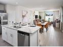 Open-concept kitchen with a stainless dishwasher that overlooks the dining and living areas at 1828 Brekey Way, Zephyrhills, FL 33541