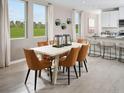 Open dining room with seating for six, bright windows and access to the kitchen at 1847 Brekey Way, Zephyrhills, FL 33541