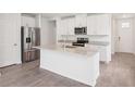 Bright kitchen featuring stainless steel appliances, a center island with a sink, and white cabinetry at 1847 Brekey Way, Zephyrhills, FL 33541