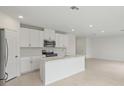 Open-concept kitchen with white cabinetry, stainless steel appliances, and a center island at 1855 Brekey Way, Zephyrhills, FL 33541