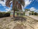 Single-story home featuring a cozy front sitting area, attached one car garage, and mature landscaping at 5415 Riddle Rd, Holiday, FL 34690