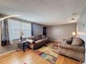Comfortable living room with hardwood floors, neutral color scheme, and ample natural light from large window at 5415 Riddle Rd, Holiday, FL 34690