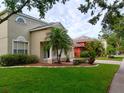 Charming two-story home featuring a well-manicured lawn and tasteful landscaping with attractive palm trees at 10415 Lucaya Dr, Tampa, FL 33647