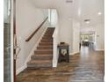 Inviting foyer with wood-look tile flooring and staircase leading to upper level at 13083 Burns Dr, Odessa, FL 33556