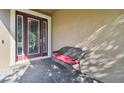 Close-up of front door with leaded glass and a bench seat on a paved porch at 13083 Burns Dr, Odessa, FL 33556