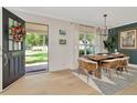 Elegant dining room with modern chandelier, table set for four and an open front door at 709 S Himes Ave, Tampa, FL 33609