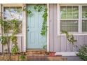 Exterior home facade showing light blue front door, windows and vegetation at 9307 N Oakleaf Ave, Tampa, FL 33612