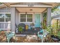 Inviting front porch with seating, plants, and a blue front door, perfect for enjoying the outdoors at 9307 N Oakleaf Ave, Tampa, FL 33612