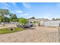 View of the exterior of this home featuring a brick paved driveway and gated fence at 10227 Parsons St, Tampa, FL 33615