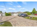 Charming single-story home featuring brick paved driveway and well-kept lawn at 10227 Parsons St, Tampa, FL 33615