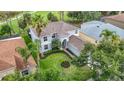 Beautiful two-story home with well-manicured lawn, mature trees, and lush tropical landscaping at 18109 Kara Ct, Tampa, FL 33647