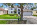 Charming two-story home with blue double door and well-maintained front yard landscaping at 18109 Kara Ct, Tampa, FL 33647