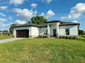 Charming single-story home with a well-manicured lawn and a paved driveway at 1732 Rada Ln, North Port, FL 34288