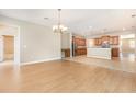 Open floor plan connecting living room to kitchen area, with neutral paint and light wood flooring at 11621 Ashton Field Ave, Riverview, FL 33579