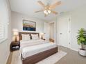 A cozy bedroom features a ceiling fan, warm lighting, and a king bed with a modern wood frame at 13210 Essman Ave, Port Charlotte, FL 33953