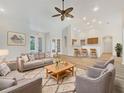 A spacious living room features neutral tones, stylish furnishings, and an open layout to the kitchen at 13210 Essman Ave, Port Charlotte, FL 33953