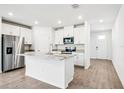 Open kitchen featuring white cabinets, granite counters, stainless steel appliances, and island at 1740 Brekey Way, Zephyrhills, FL 33541