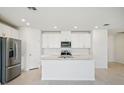 Modern open kitchen with stainless steel appliances, white cabinets, and a large center island at 1859 Draughton Dr, Zephyrhills, FL 33541