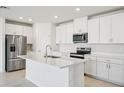 Bright kitchen featuring stainless steel appliances, white cabinetry, and center island at 1859 Draughton Dr, Zephyrhills, FL 33541