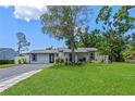 Inviting single-story home boasts a spacious front yard, well-manicured lawn, and a modern driveway at 2110 W Farwell Dr, Tampa, FL 33603
