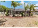 Screened-in patio area surrounded by lush landscaping, offering a private outdoor space at 2707 Wood Pointe Dr, Holiday, FL 34691